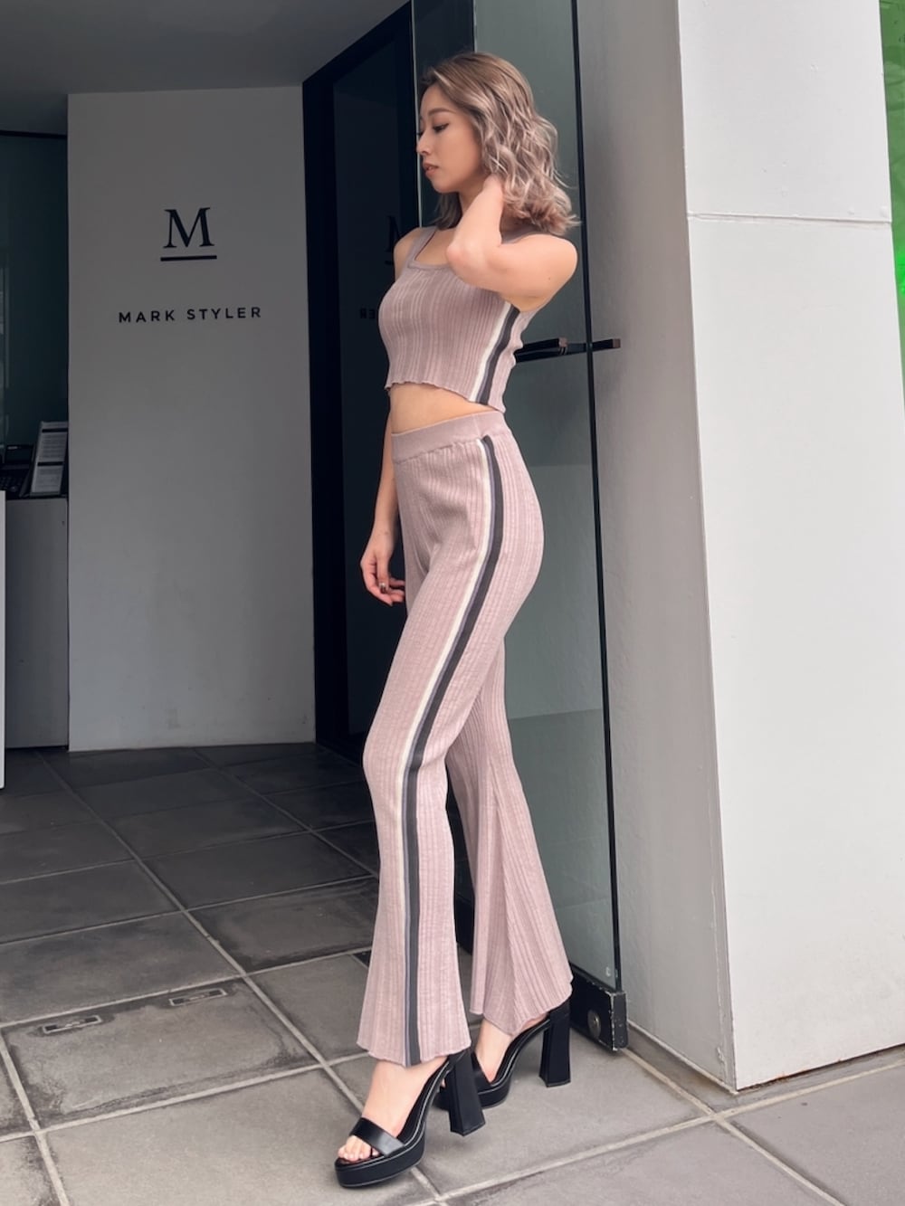 ピンク系のニット/セーター、ピンク系のその他パンツ、ブラック系のサンダルを着用したレディースの夏コーディネートの2枚目の写真