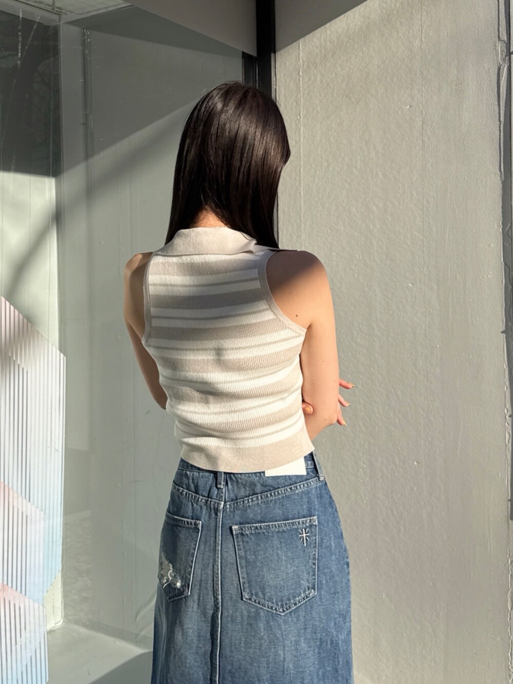 ブルー系のデニムスカート、ベージュ系のニット/セーターを着用したレディースの夏コーディネートの4枚目の写真