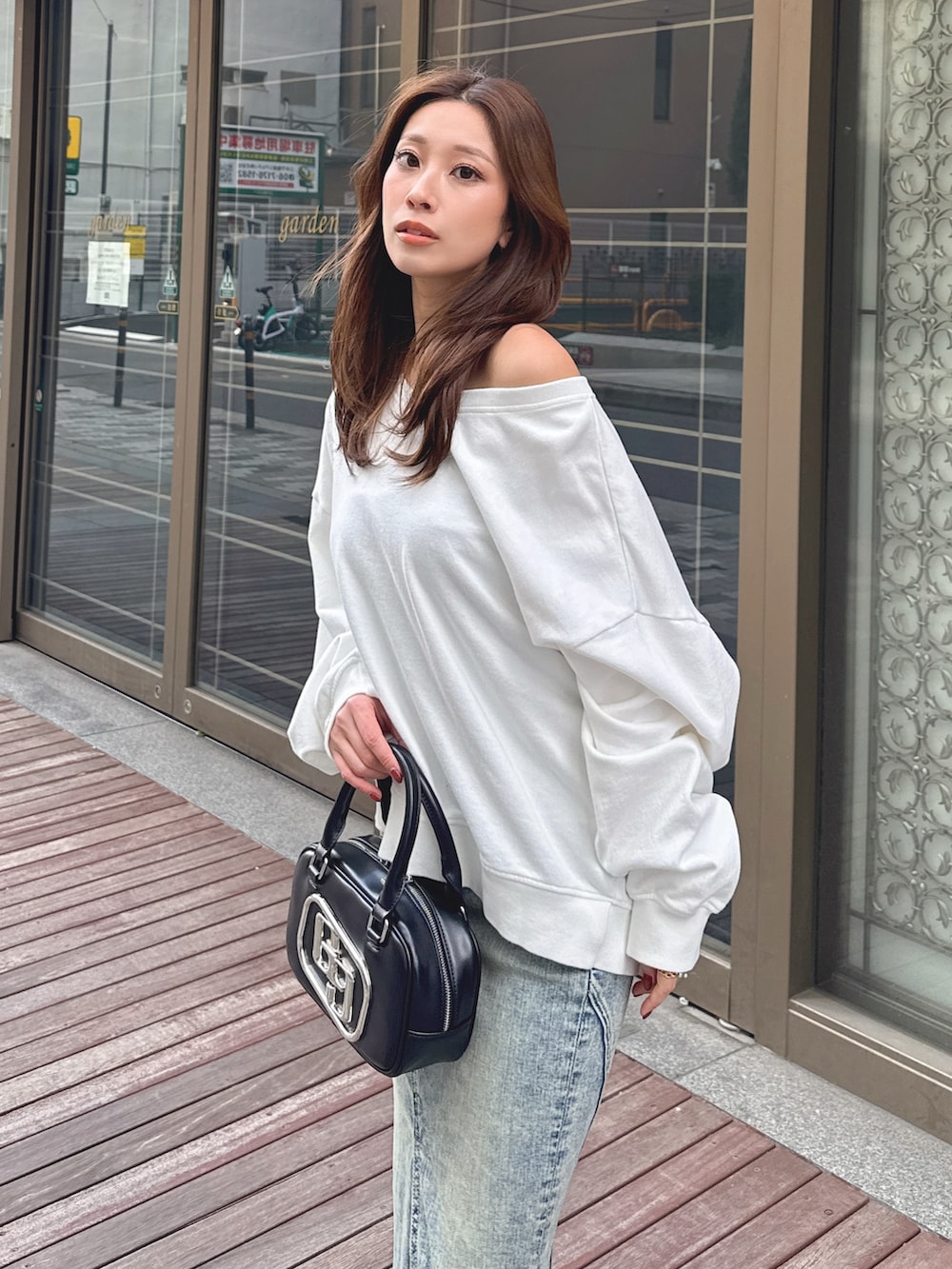 ホワイト系のスウェット、ブルー系のデニムスカートを着用したレディースの冬コーディネートの4枚目の写真