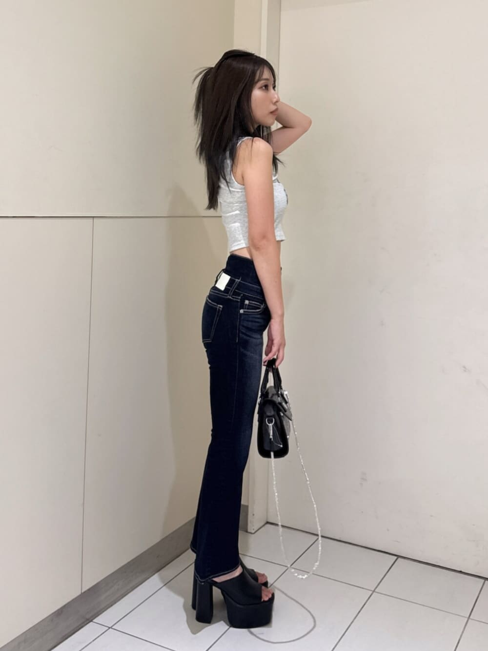 ブルー系のデニムパンツ、グレー系のタンクトップ、ブラック系のサンダルを着用したレディースの夏コーディネートの4枚目の写真