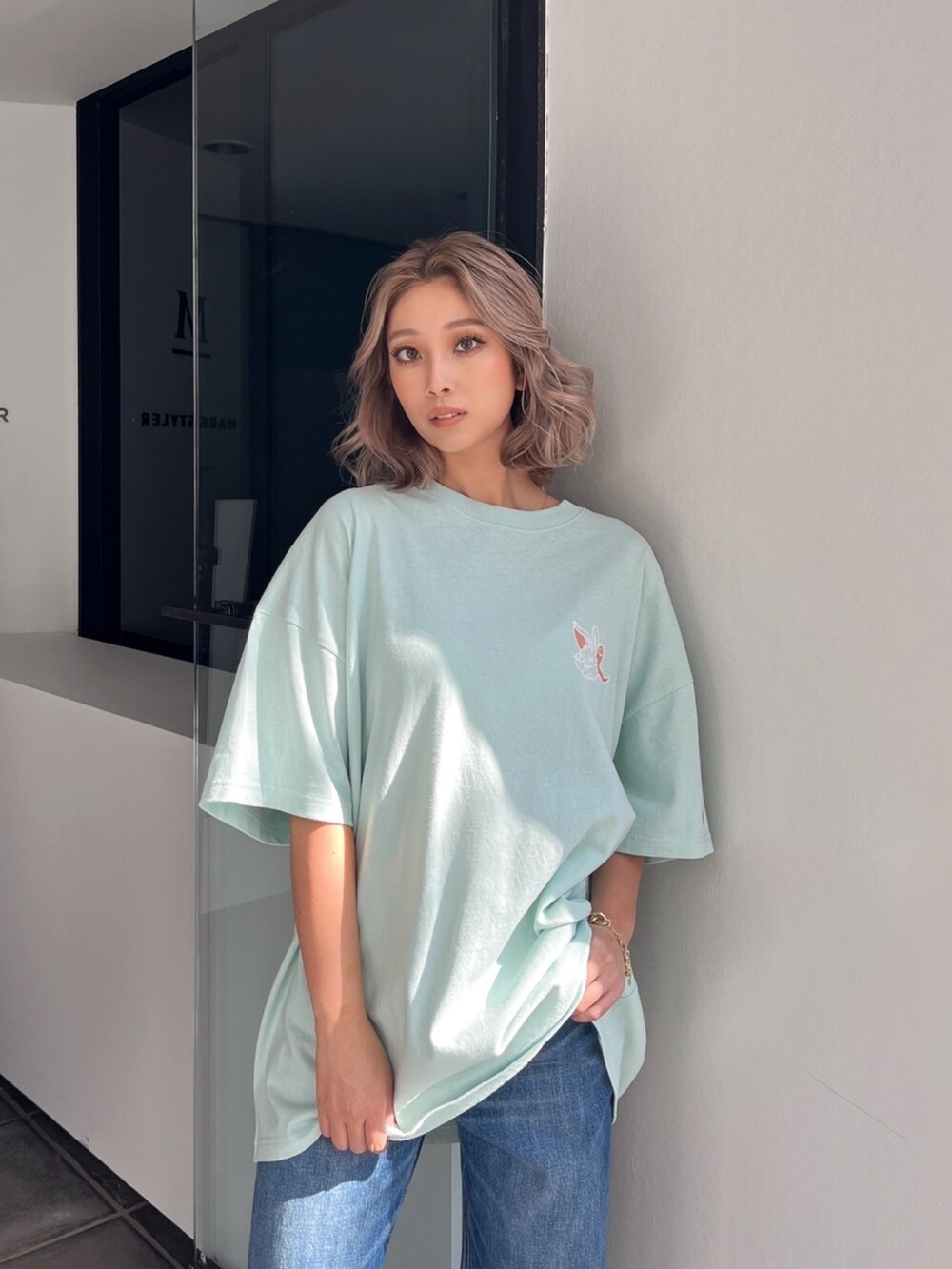 グリーン系のTシャツ/カットソーを着用したレディースの春コーディネートの3枚目の写真