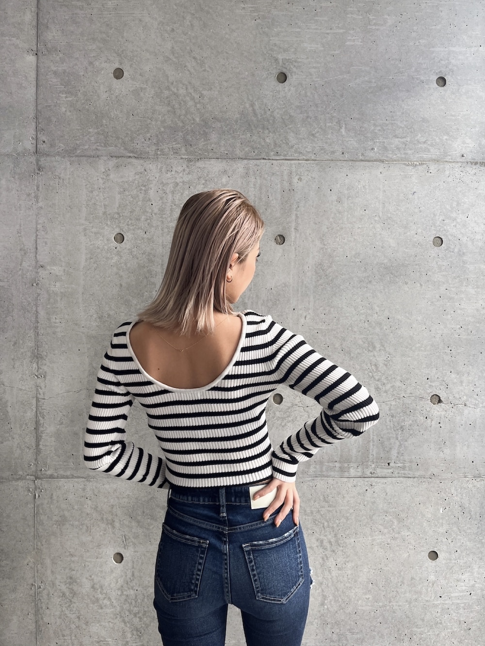 ブラック系のブーツ、ブルー系のデニムパンツ、その他のニット/セーターを着用したレディースの冬コーディネートの3枚目の写真