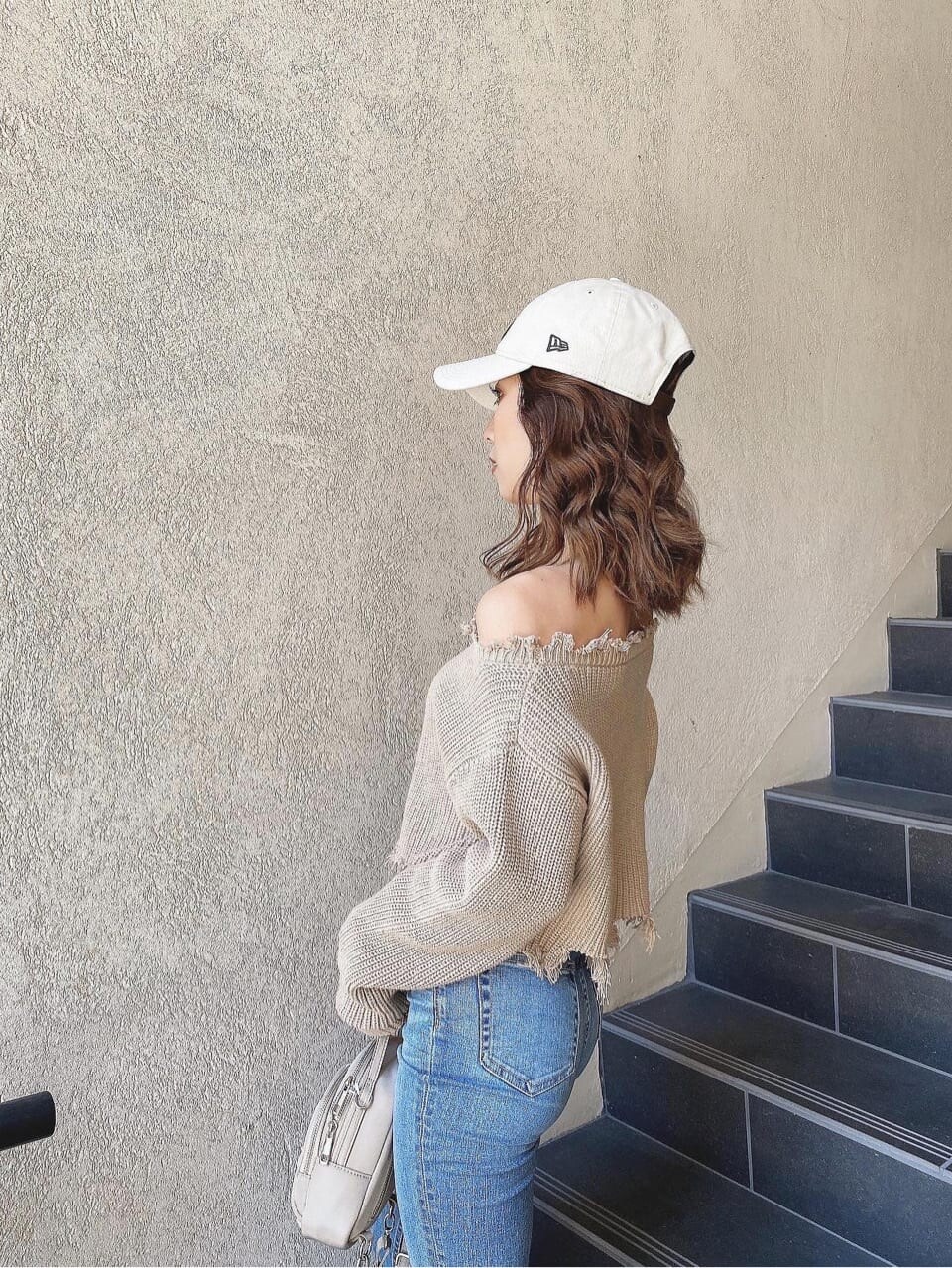 ブルー系のデニムパンツ、ベージュ系のニット/セーター、ホワイト系のキャップを着用したレディースの冬コーディネートの9枚目の写真