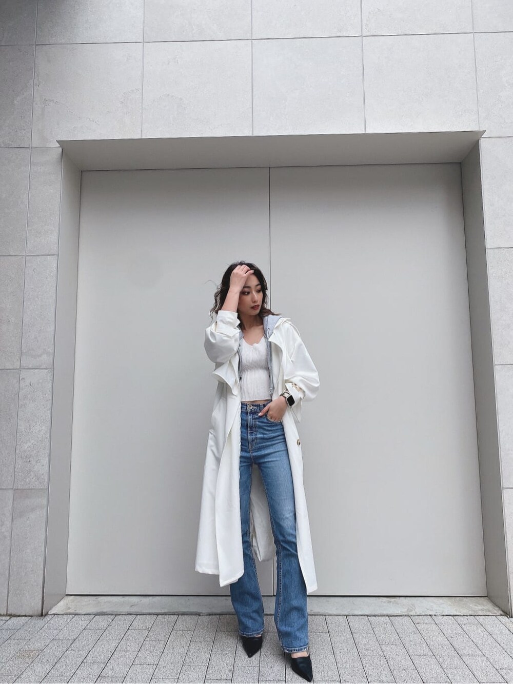 ブラック系のパンプス、ホワイト系のトレンチコート、ホワイト系のニット/セーターを着用したレディースの冬コーディネートの2枚目の写真