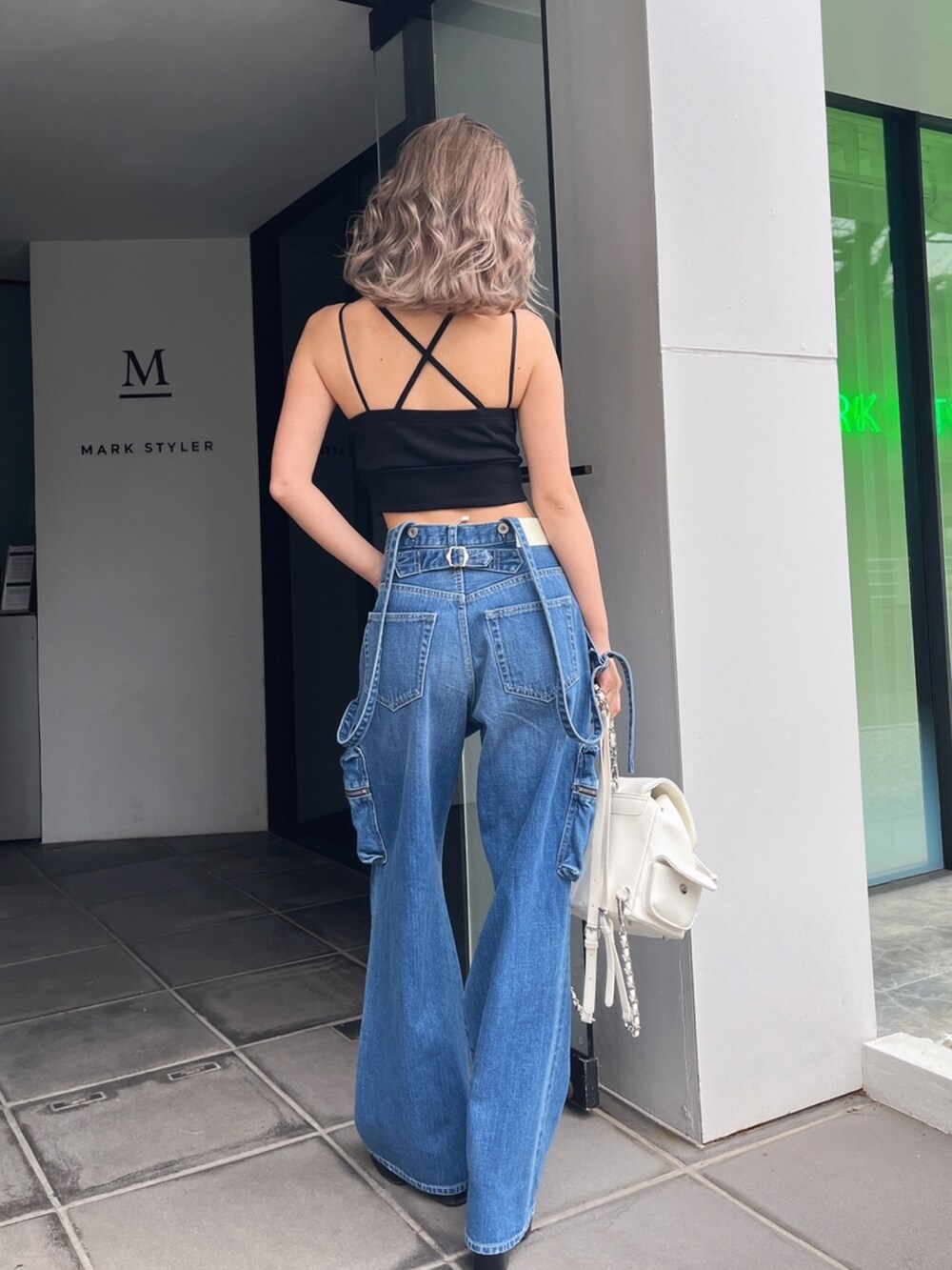 ブラック系のキャミソール、ブルー系のデニムパンツを着用したレディースの夏コーディネートの4枚目の写真