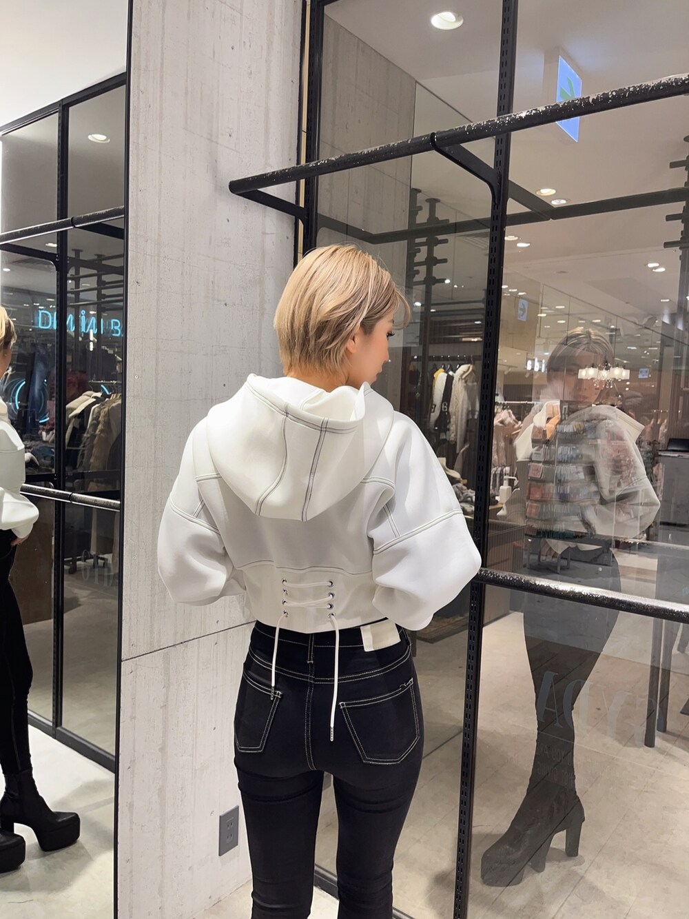 ブラック系のデニムパンツ、ホワイト系のパーカーを着用したレディースの冬コーディネートの5枚目の写真