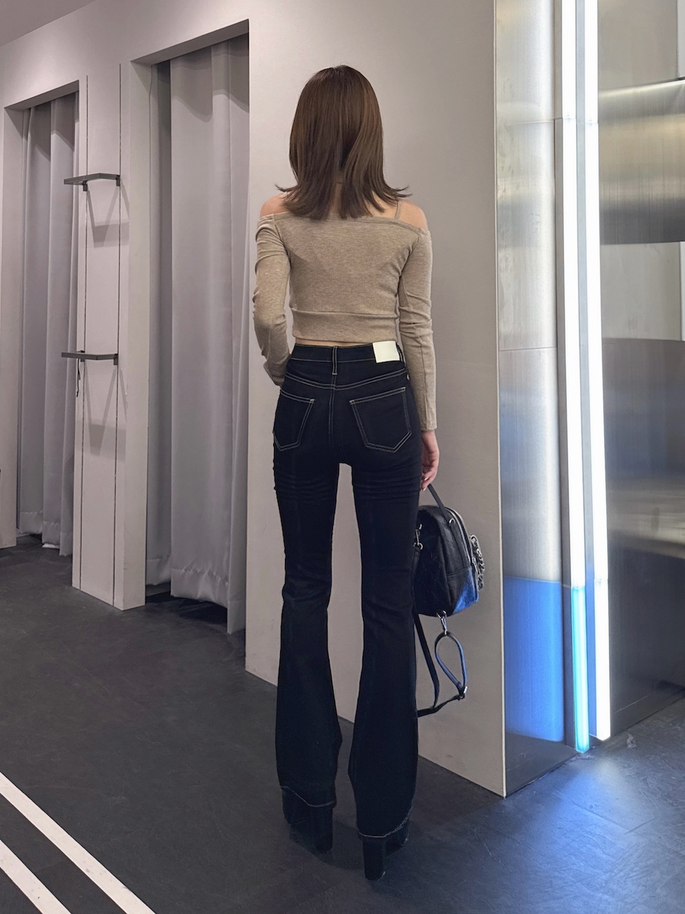 ベージュ系のTシャツ/カットソー、ブラック系のデニムパンツ、ブラック系のバックパック/リュックを着用したレディースの秋コーディネートの3枚目の写真
