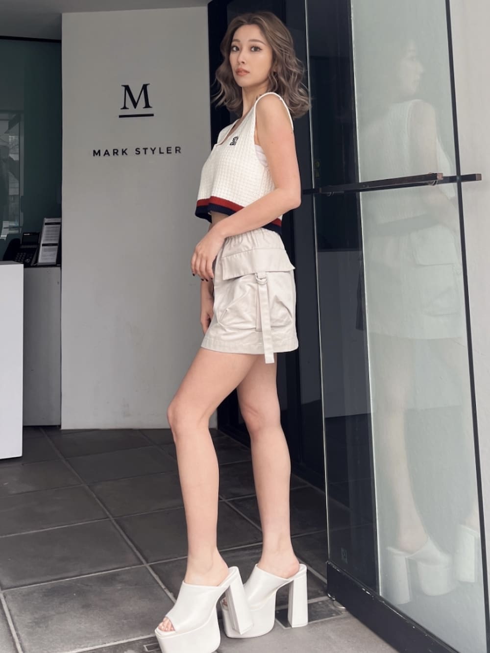 ホワイト系のニット/セーター、ホワイト系のカーゴパンツ、ブラック系のサンダルを着用したレディースの秋コーディネートの2枚目の写真