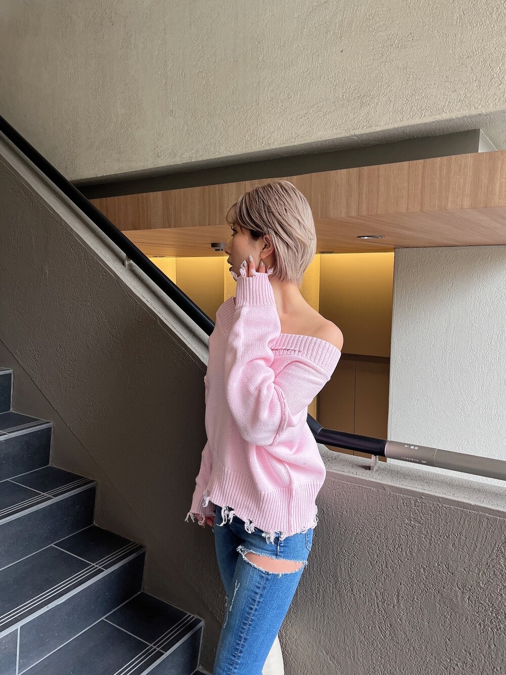 ピンク系のニット/セーター、ブルー系のデニムパンツ、ホワイト系のブーツを着用したレディースの冬コーディネートの3枚目の写真