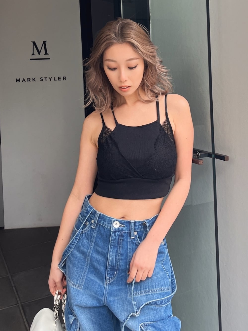 ブラック系のキャミソール、ブルー系のデニムパンツを着用したレディースの夏コーディネートの3枚目の写真