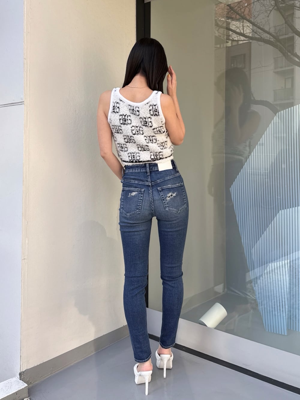 ホワイト系のニット/セーター、ブルー系のデニムパンツを着用したレディースの夏コーディネートの2枚目の写真