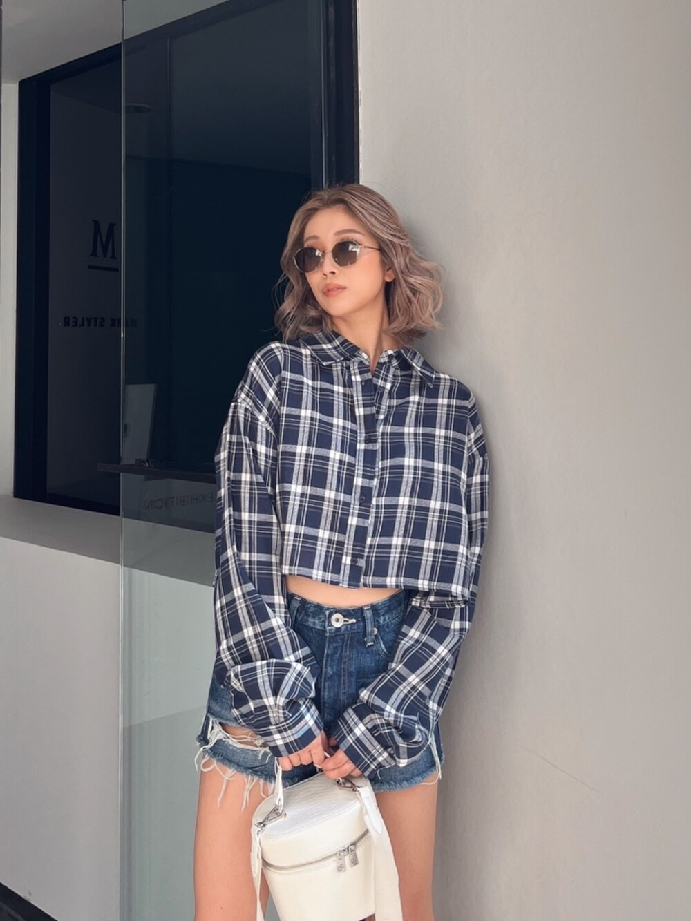 ブルー系のシャツ/ブラウス、ブラック系のハンドバッグ、ブラウン系のサングラスを着用したレディースの春コーディネートの3枚目の写真