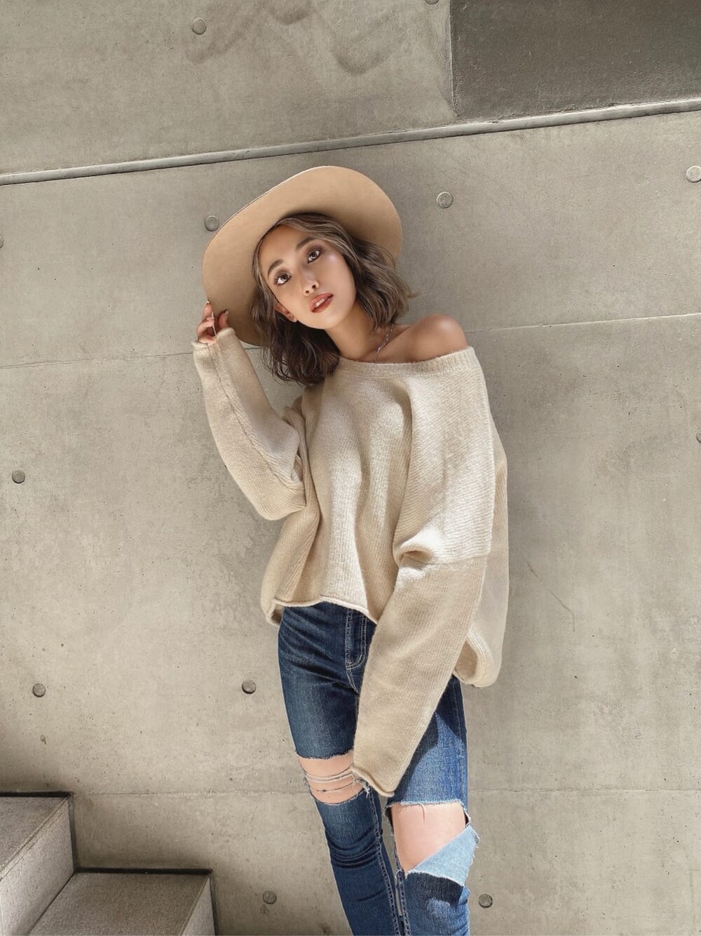 ブラック系のブーツ、ホワイト系のニット/セーター、ブルー系のデニムパンツを着用したレディースの秋コーディネートの4枚目の写真