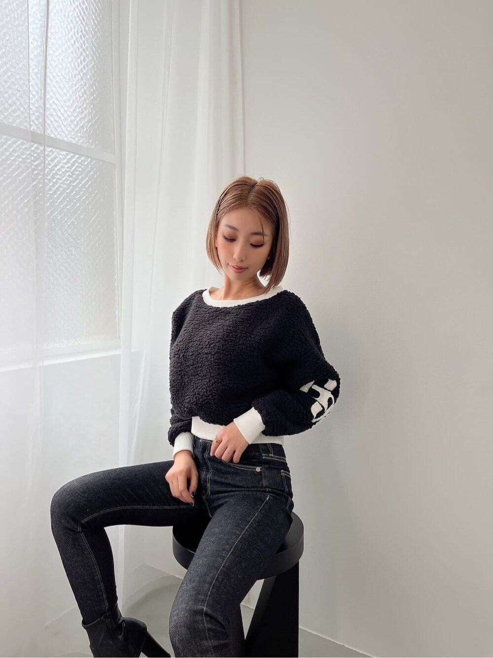 ブラック系のブーツ、ブラック系のデニムパンツ、ブラック系のデニムパンツを着用したレディースの秋コーディネートの4枚目の写真