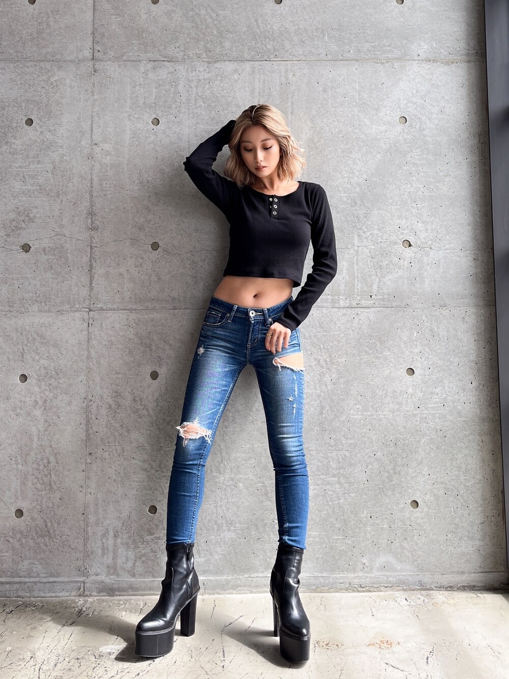 ブラック系のTシャツ/カットソー、ブルー系のデニムパンツ、ブラック系のブーツを着用したレディースの秋コーディネートの2枚目の写真