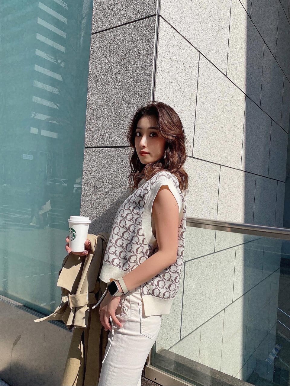 ベージュ系のトレンチコート、ホワイト系のデニムパンツ、ホワイト系のニット/セーターを着用したレディースの春コーディネートの9枚目の写真