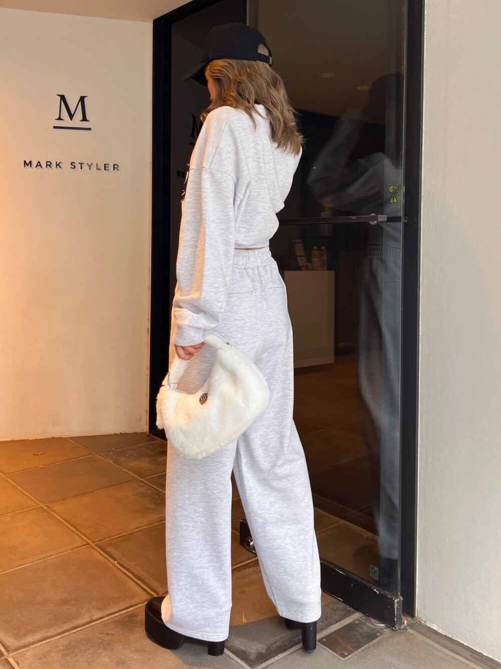 グレー系のスウェット、グレー系のスウェットパンツ、ブラック系のブーツを着用したレディースの冬コーディネートの2枚目の写真