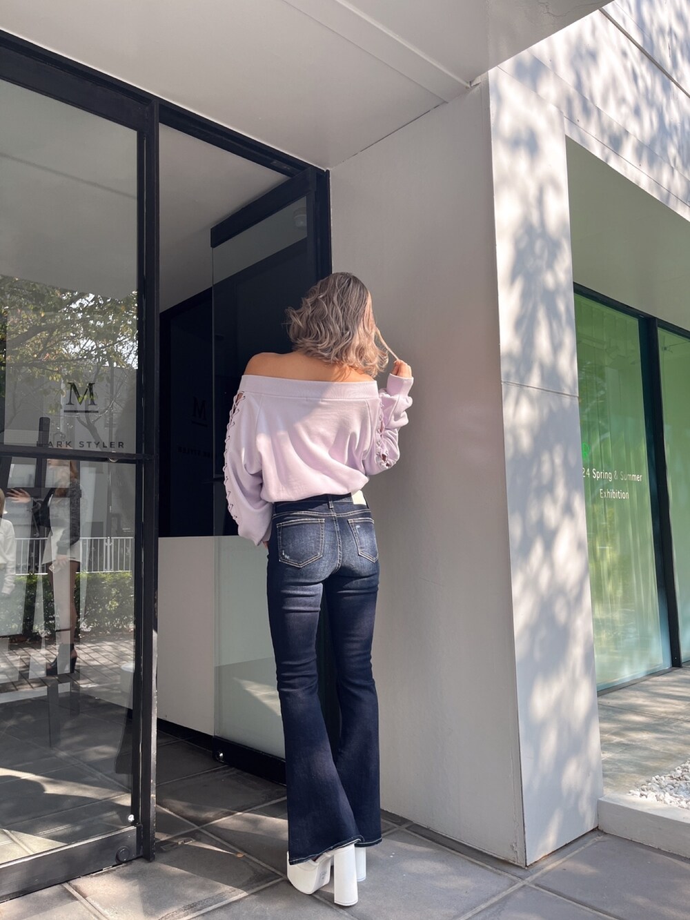 パープル系のスウェット、ブルー系のデニムパンツを着用したレディースの春コーディネートの3枚目の写真