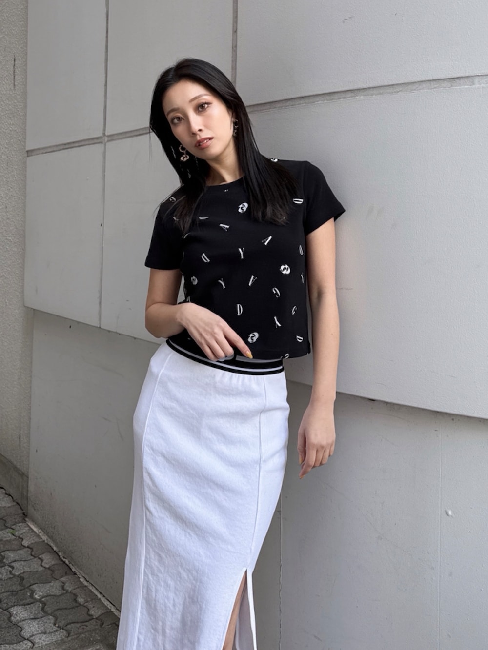 ブラック系のTシャツ/カットソー、ホワイト系のスカートを着用したレディースの秋コーディネートの5枚目の写真