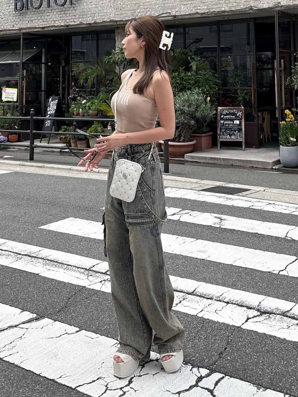 ベージュ系のキャミソール、ブルー系のデニムパンツ、ホワイト系のサンダルを着用したレディースの夏コーディネートの2枚目の写真
