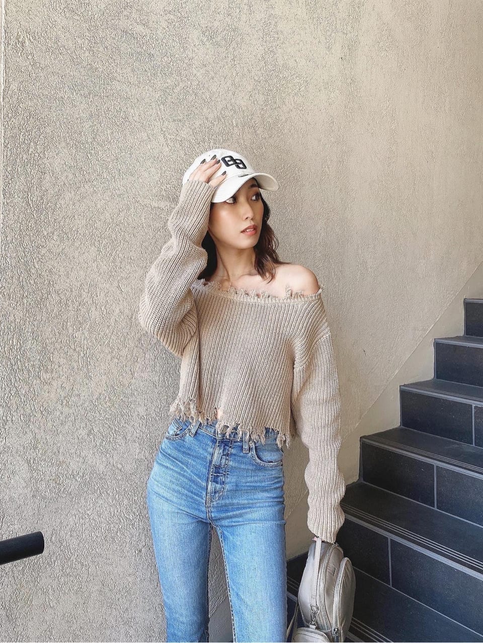 ブルー系のデニムパンツ、ベージュ系のニット/セーター、ホワイト系のキャップを着用したレディースの冬コーディネートの8枚目の写真