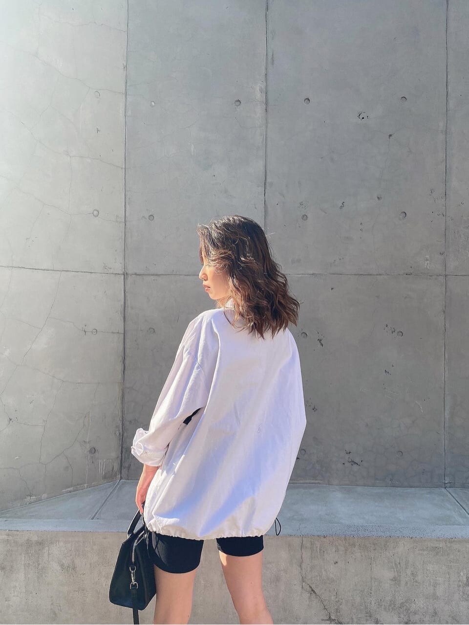 ホワイト系のブルゾン、ブラック系のレギンス/スパッツを着用したレディースの春コーディネートの2枚目の写真