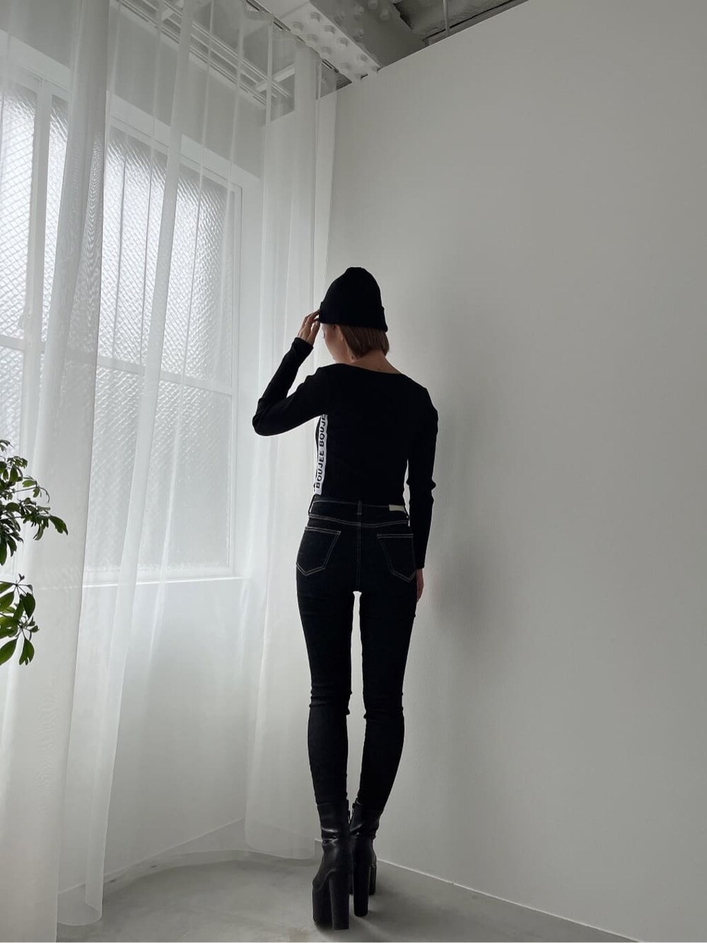 ブラック系のデニムパンツ、ブラック系のブーツ、ブラック系のデニムパンツを着用したレディースの秋コーディネートの3枚目の写真