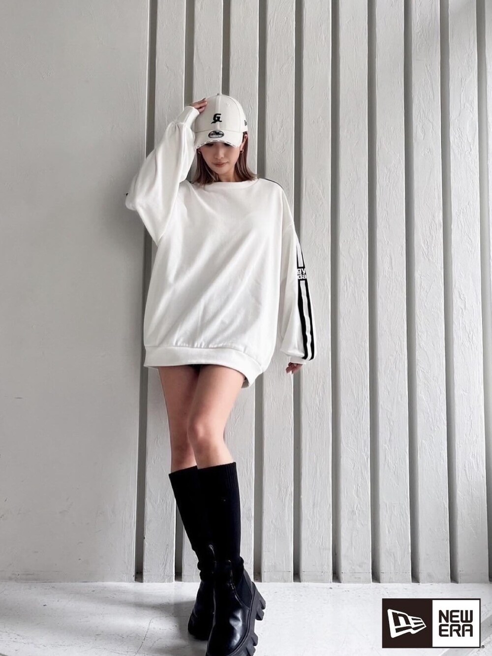 ホワイト系のスウェット、ブラック系のブーツを着用したレディースの春コーディネートの3枚目の写真