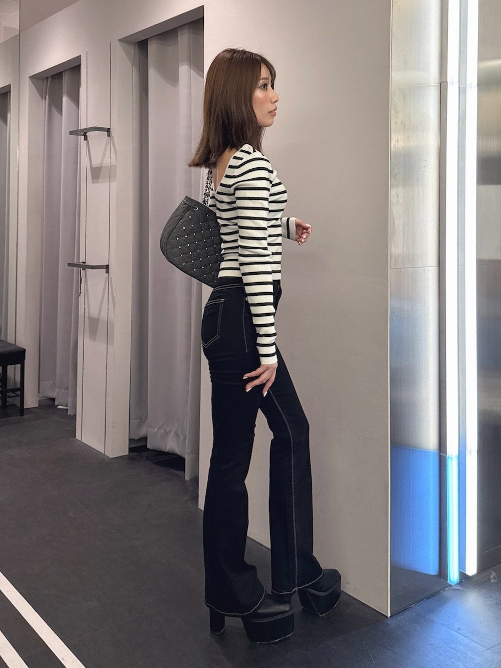 ブラック系のデニムパンツ、ブラック系のブーツ、その他のニット/セーターを着用したレディースの秋コーディネートの3枚目の写真