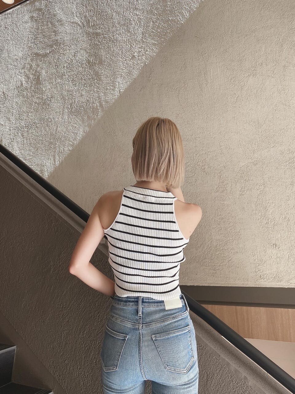 ブルー系のデニムパンツ、ホワイト系のタンクトップを着用したレディースの夏コーディネートの2枚目の写真