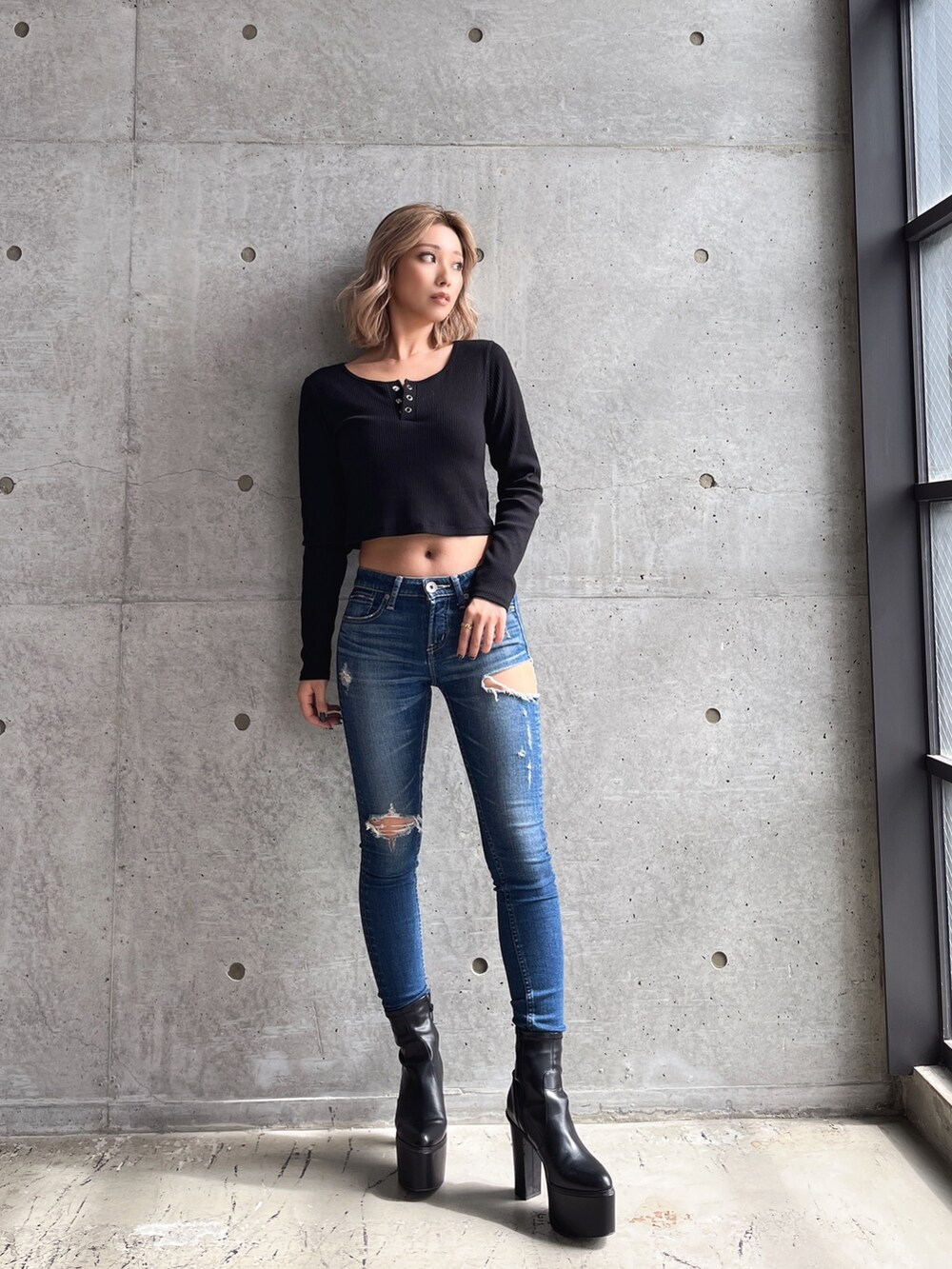 ブラック系のTシャツ/カットソー、ブルー系のデニムパンツ、ブラック系のブーツを着用したレディースの秋コーディネートの3枚目の写真