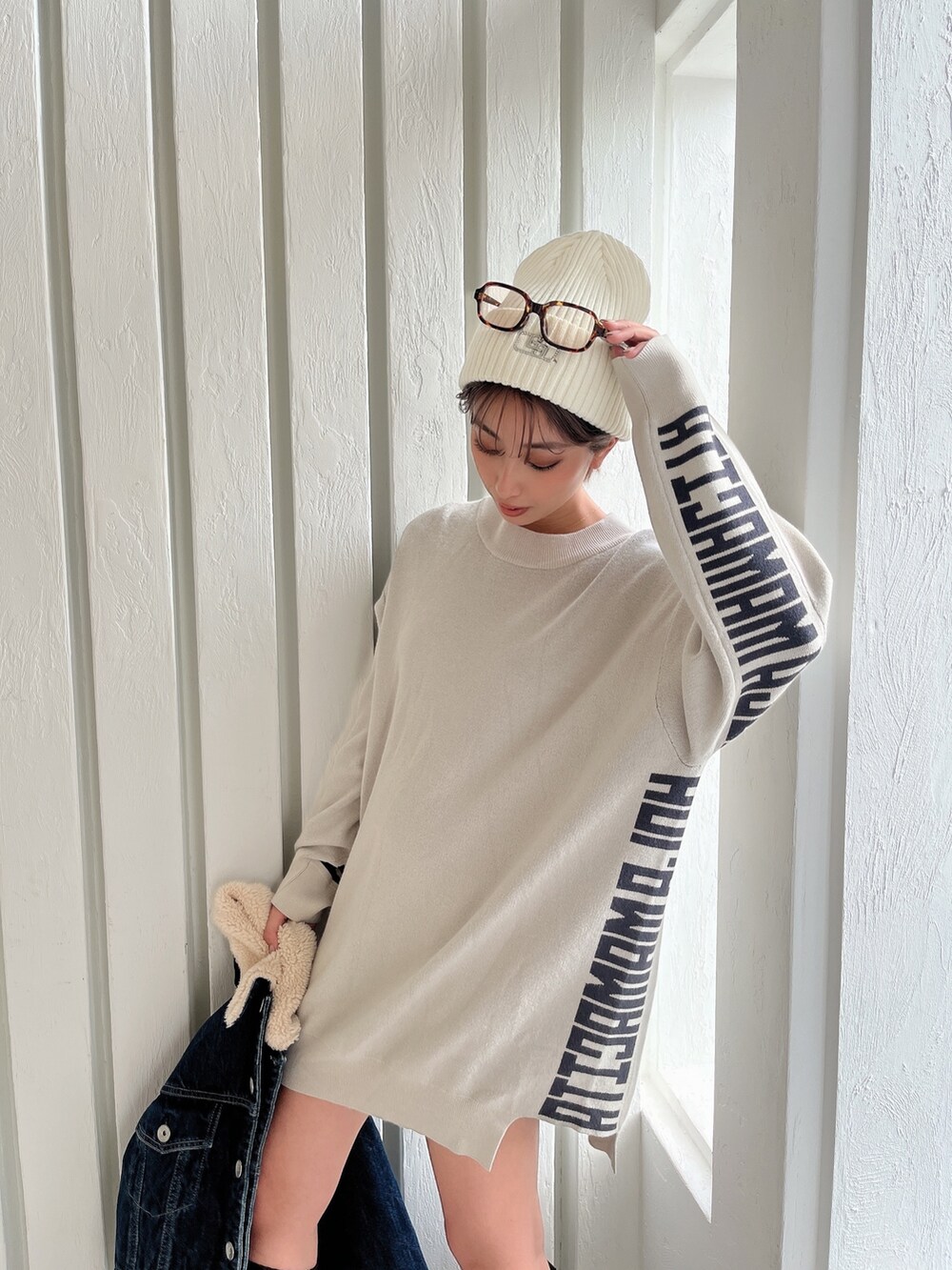 ホワイト系のニット/セーター、ブルー系のデニムジャケット、ブラック系のブーツを着用したレディースの秋コーディネートの7枚目の写真