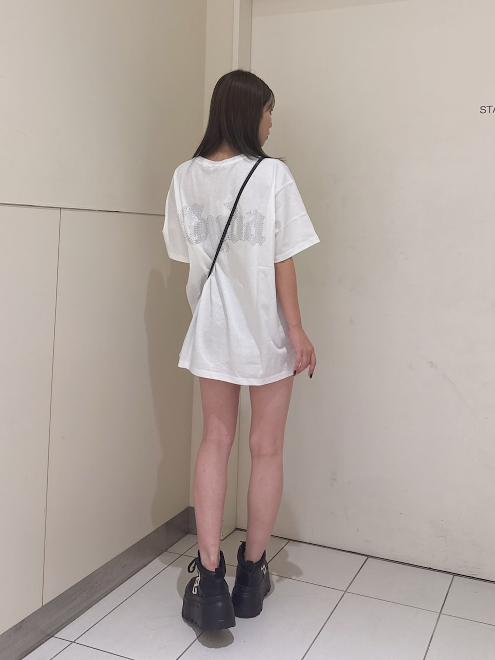 ホワイト系のTシャツ/カットソー、ブラック系のスニーカーを着用したレディースの夏コーディネートの3枚目の写真