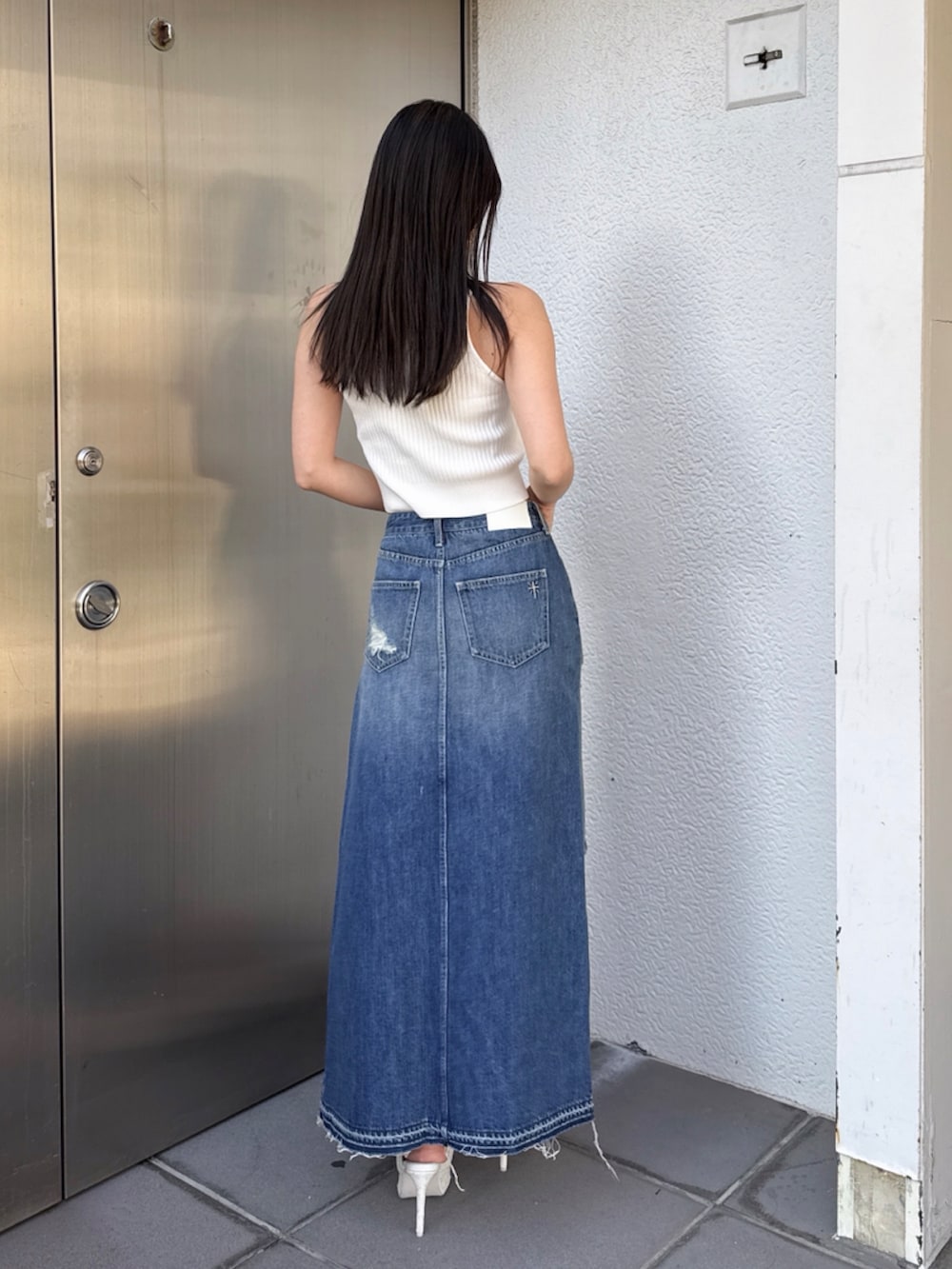 ブルー系のデニムスカートを着用したレディースの夏コーディネートの2枚目の写真