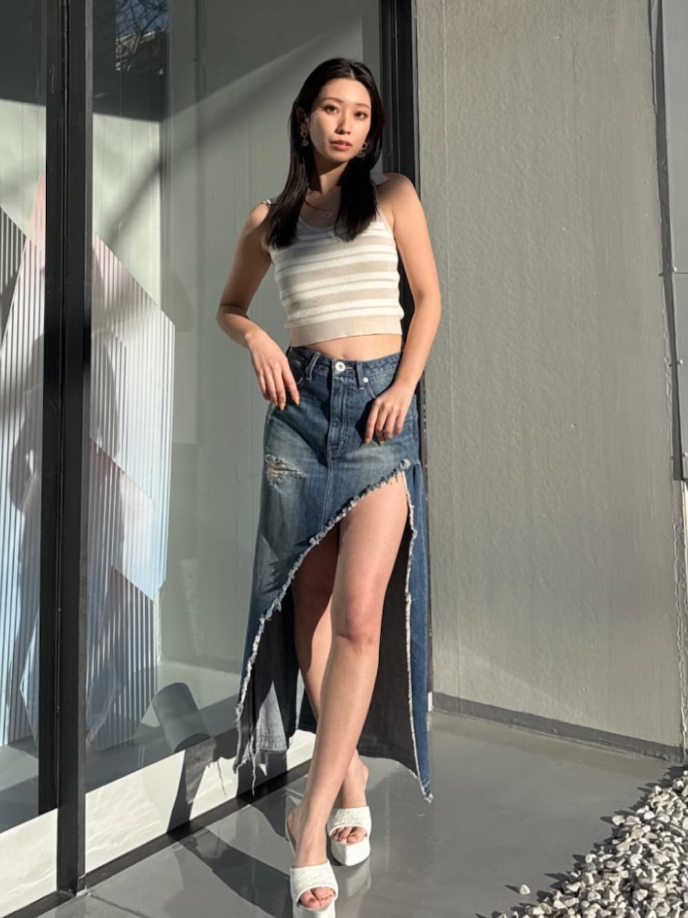 ブルー系のデニムスカート、ベージュ系のニット/セーターを着用したレディースの夏コーディネートの3枚目の写真