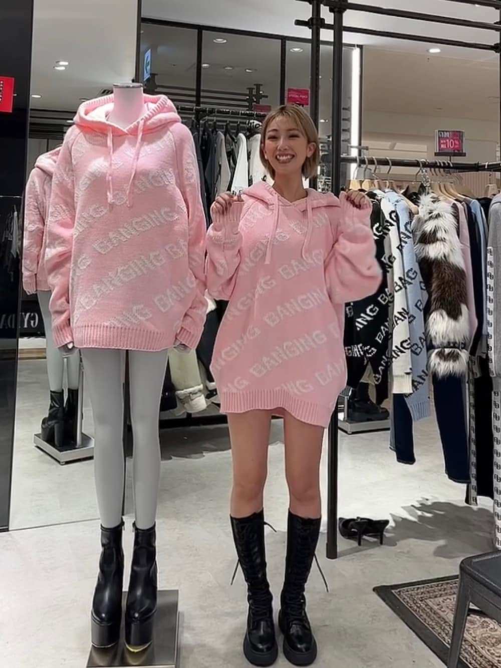 グレー系のワンピース、ブラック系のブーツ、ピンク系のニット/セーターを着用したレディースの冬コーディネートの2枚目の写真