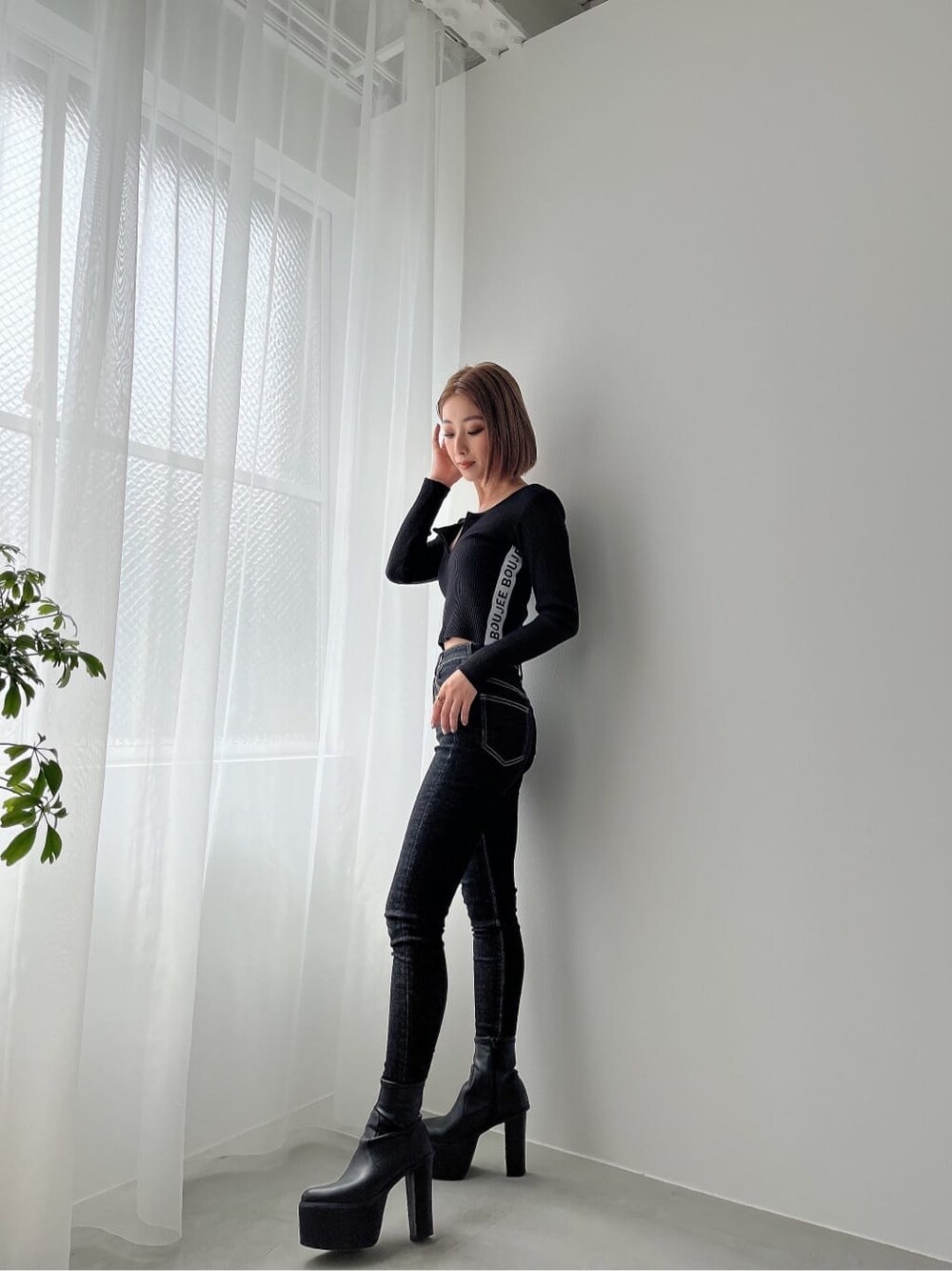 ブラック系のデニムパンツ、ブラック系のブーツ、ブラック系のデニムパンツを着用したレディースの秋コーディネートの2枚目の写真