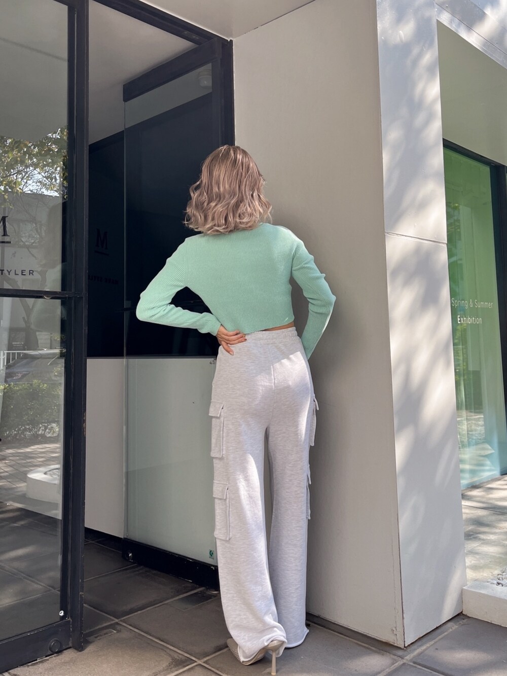 グレー系のカーゴパンツ、グリーン系のカーディガン/ボレロ、ベージュ系のパンプスを着用したレディースの冬コーディネートの4枚目の写真