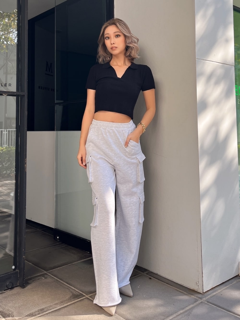 ブラック系のニット/セーター、グレー系のカーゴパンツ、ベージュ系のパンプスを着用したレディースの春コーディネートの2枚目の写真