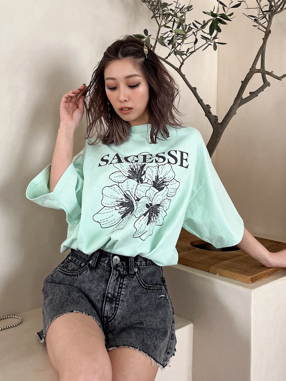 ブラック系のデニムパンツ、グリーン系のTシャツ/カットソーを着用したレディースの夏コーディネートの2枚目の写真