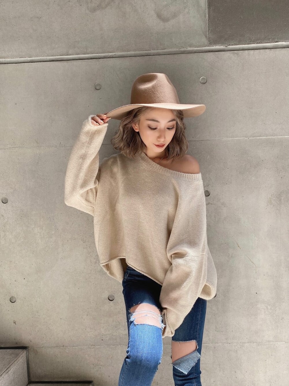 ブラック系のブーツ、ホワイト系のニット/セーター、ブルー系のデニムパンツを着用したレディースの秋コーディネートの3枚目の写真