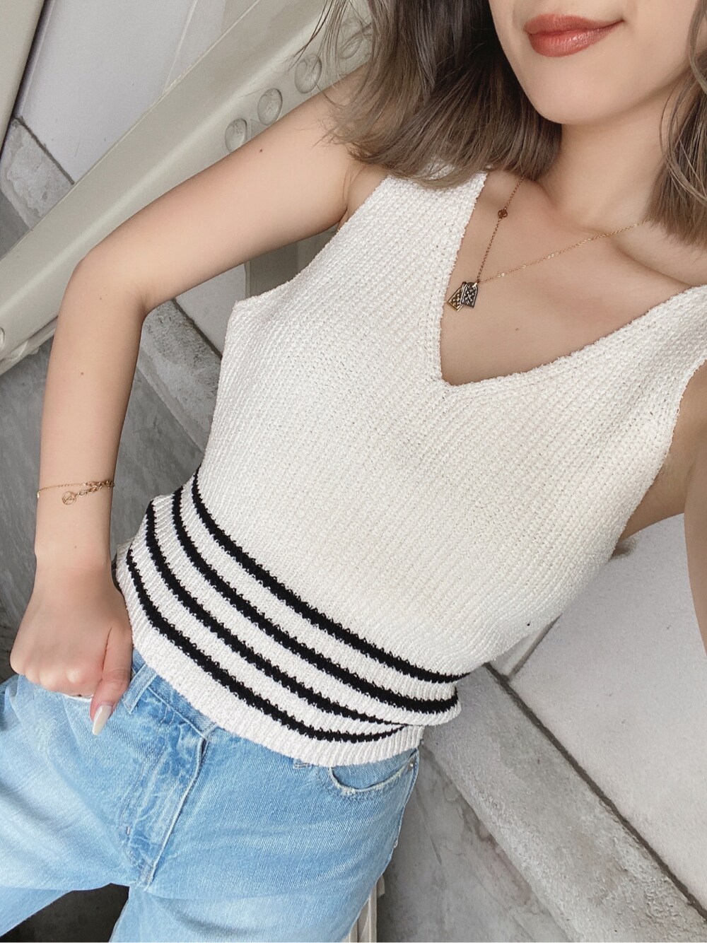 ホワイト系のニット/セーターを着用したレディースの春コーディネートの2枚目の写真