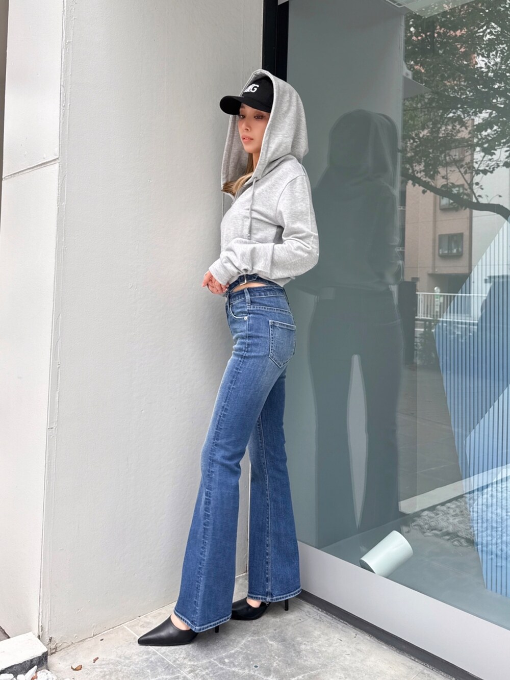 ブルー系のデニムパンツ、グレー系のパーカーを着用したレディースの春コーディネートの2枚目の写真