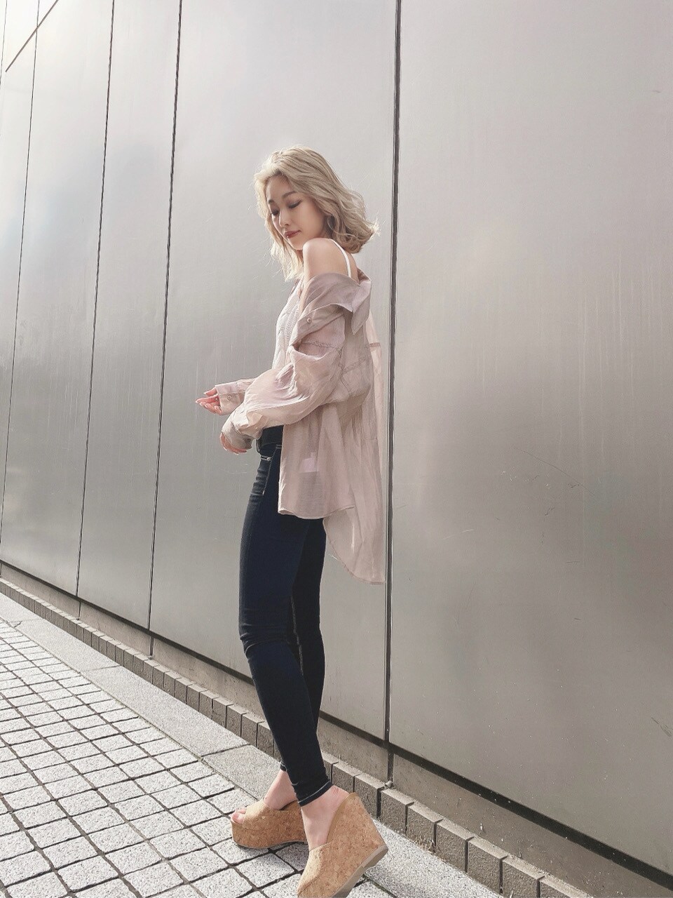 ブラウン系のサンダル、ホワイト系のキャミソール、ブラック系のデニムパンツを着用したレディースの春コーディネートの2枚目の写真