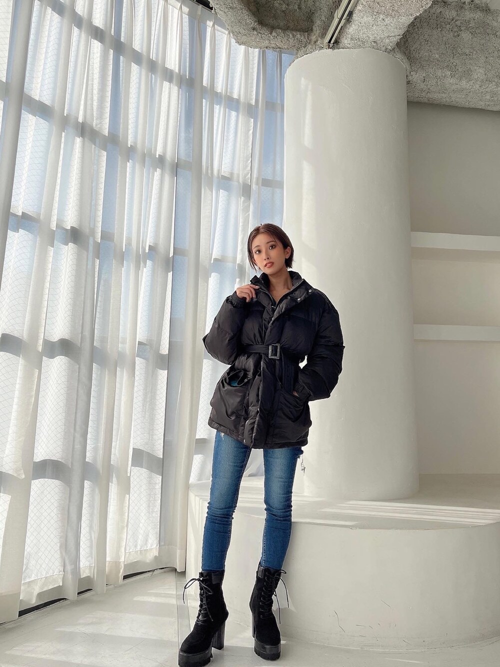 ブラック系のMA-1、ブルー系のデニムパンツ、ブラック系のブーツを着用したレディースの秋コーディネートの3枚目の写真