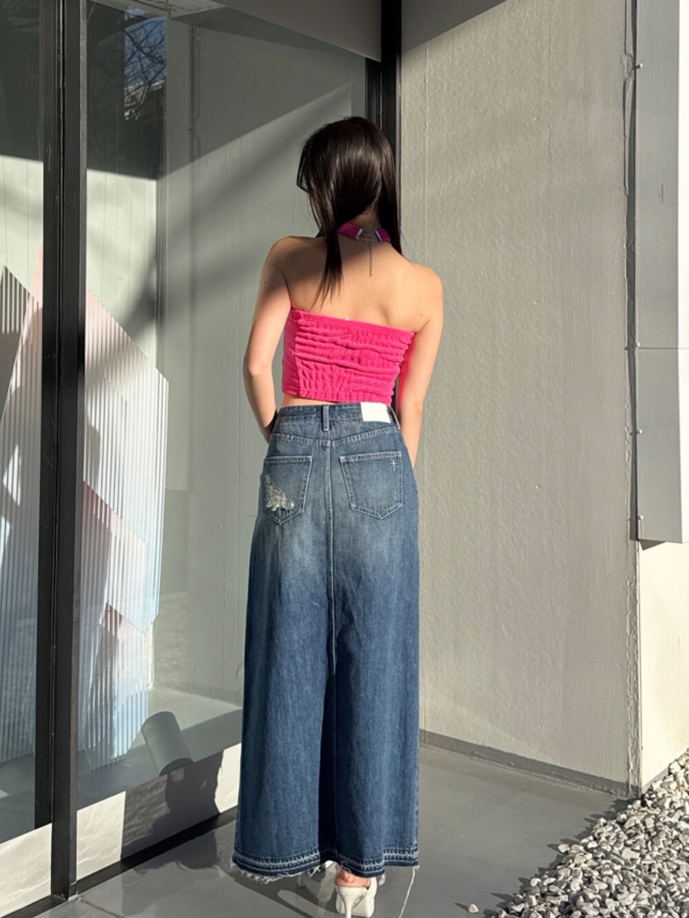 ブルー系のデニムスカートを着用したレディースの夏コーディネートの2枚目の写真