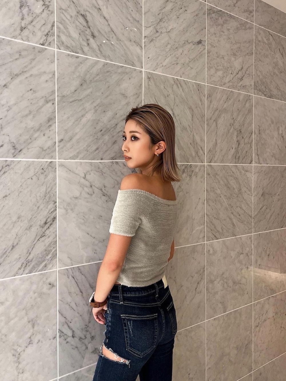 ベージュ系のニット/セーター、ブルー系のデニムパンツ、ブラック系のブーツを着用したレディースの夏コーディネートの4枚目の写真