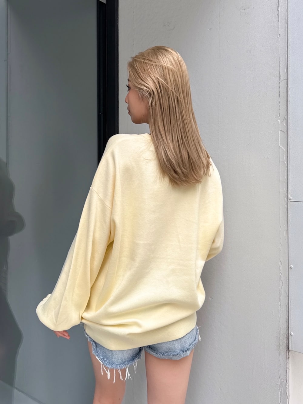 ブルー系のデニムパンツ、イエロー系のニット/セーターを着用したレディースの冬コーディネートの2枚目の写真