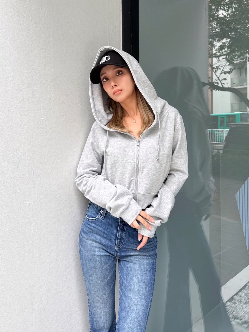 ブルー系のデニムパンツ、グレー系のパーカーを着用したレディースの春コーディネートの4枚目の写真