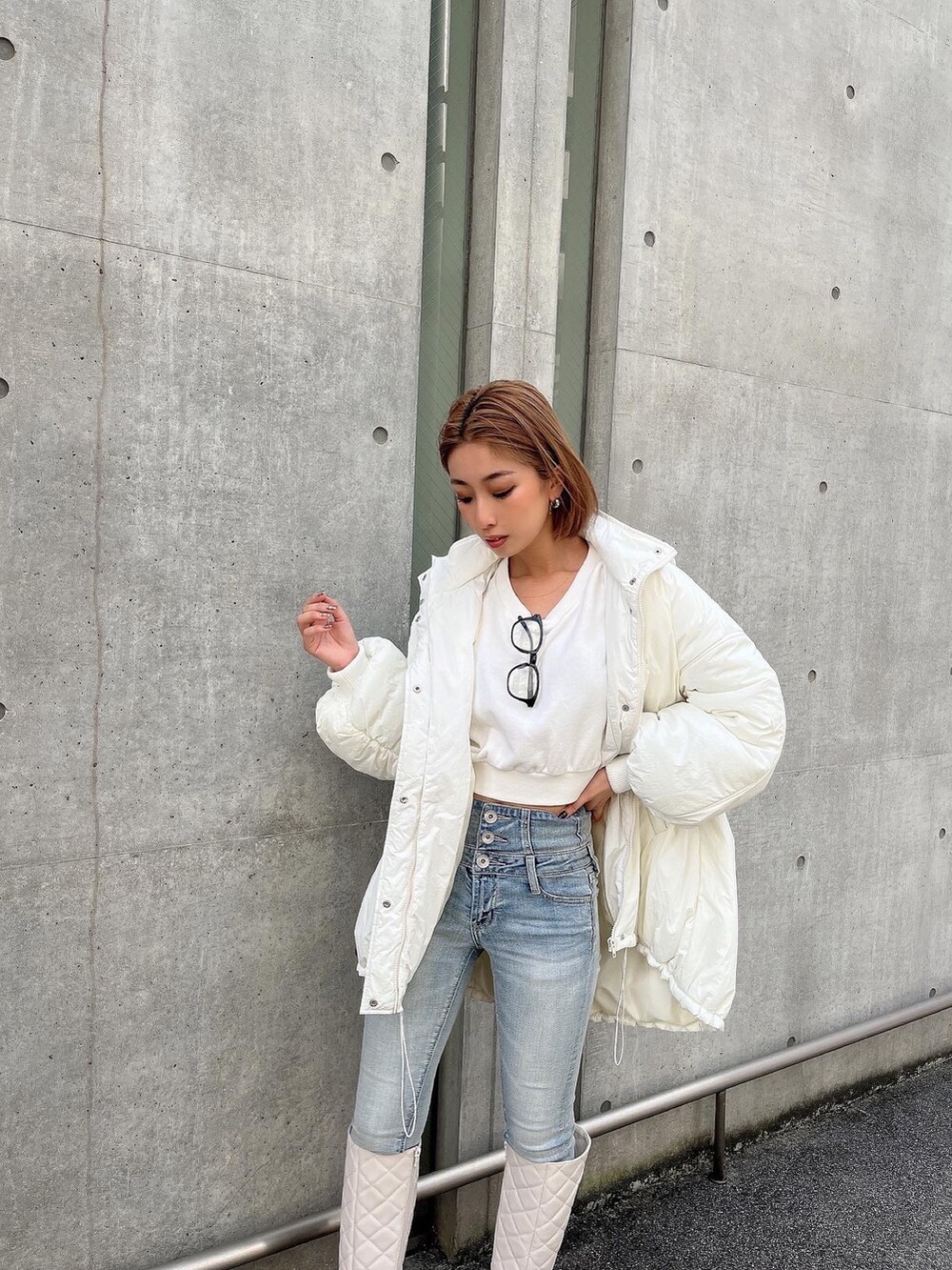 ホワイト系のブルゾン、ホワイト系のスウェット、ブラック系のブーツを着用したレディースの冬コーディネートの3枚目の写真